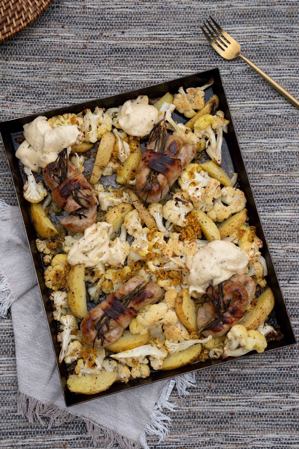 Traybake met bloemkool, chipolata en kaassaus